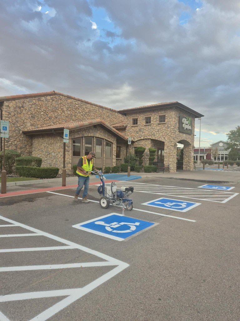 Worker line-painting handicap symbols at Olive Garden