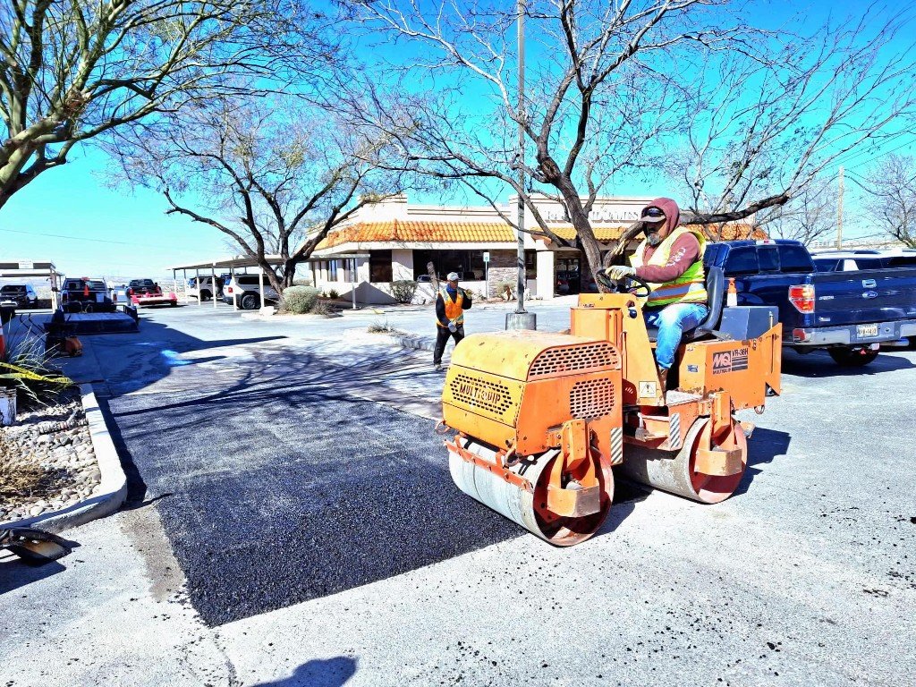 Road roller compacting fresh asphalt patch